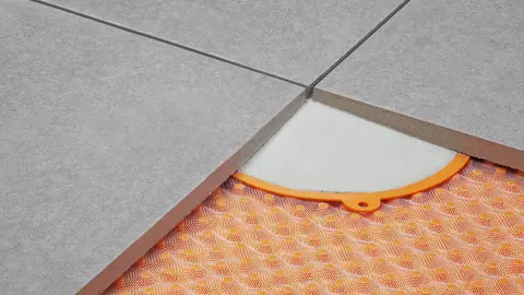 Met dunbedmortelpunten bevestigde terrastegels op een oppervlaktedrainage