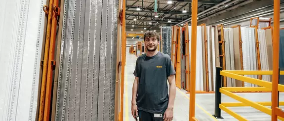 Logistik-Mitarbeiter steht im Logistikzentrum vor Lagerregalen