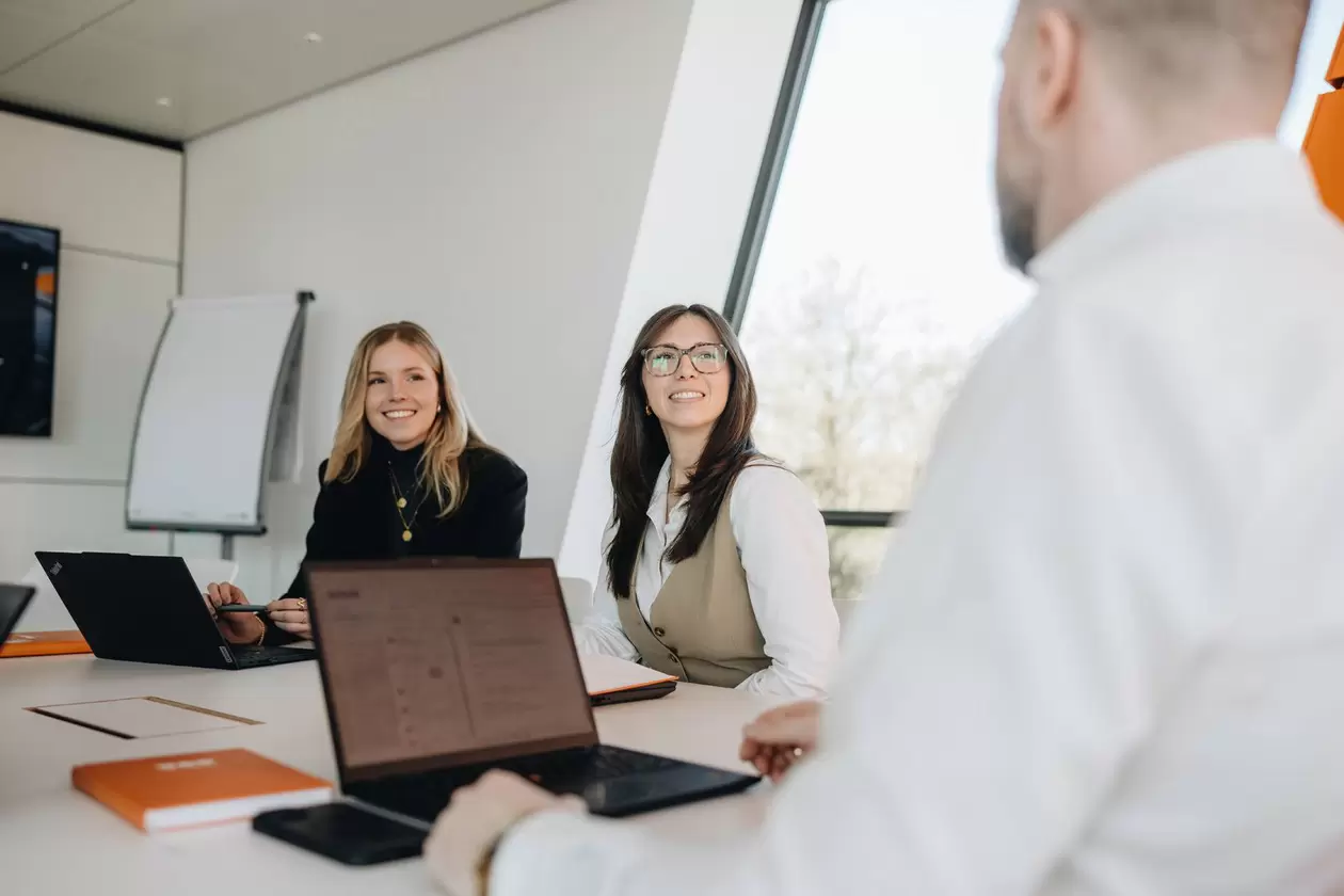 Gespr&auml;chssituation zwischen mehreren Mitarbeitern im Besprechungsraum