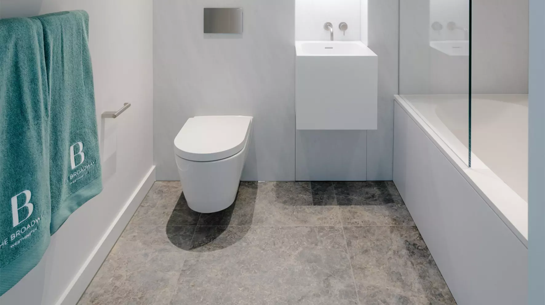 Moderne badkamer met vrijhangende wastafels, toilet en ligbad.
