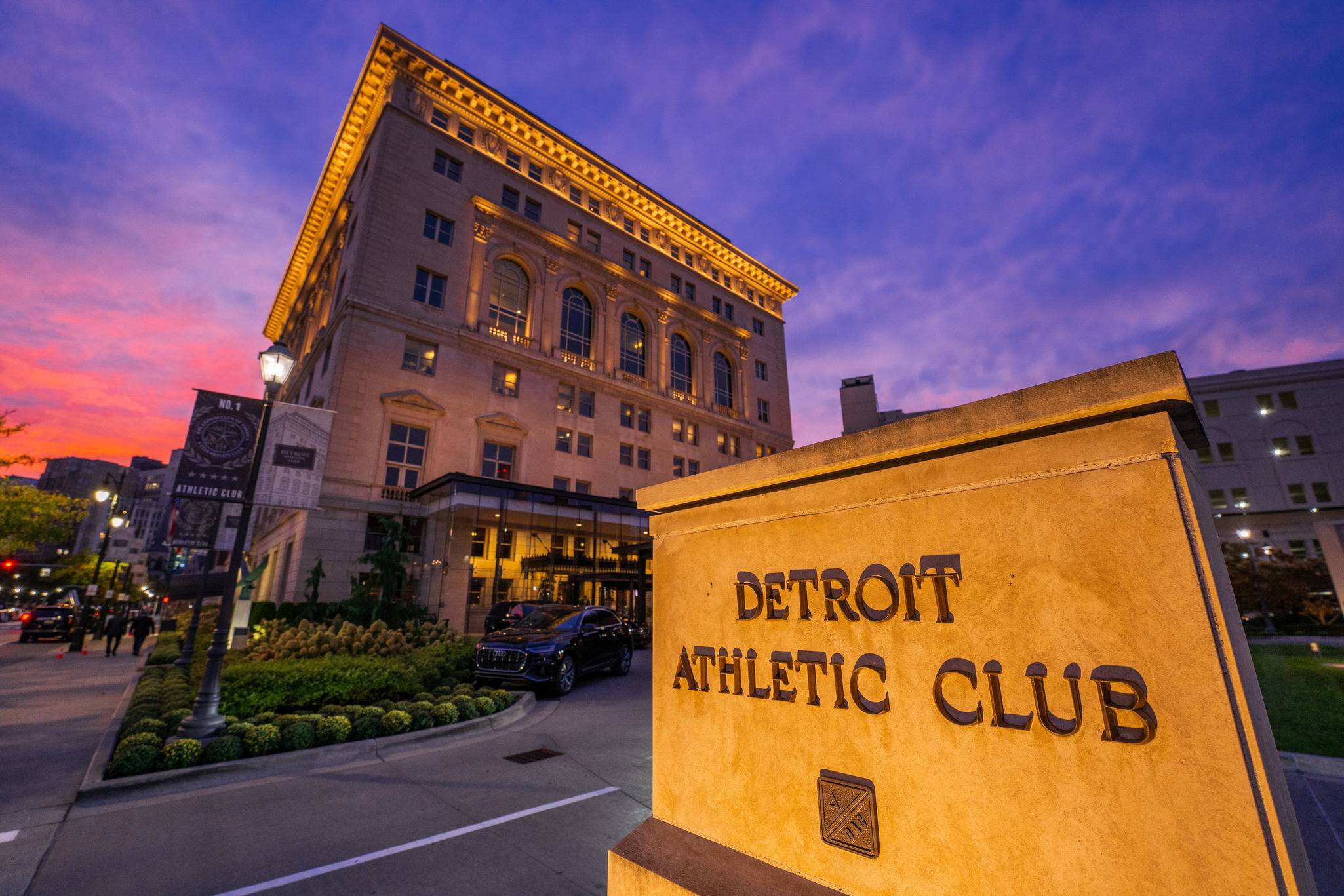 Detroit Athletic Club entrance sign and clubhouse facade illuminated at dusk