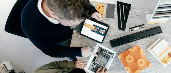 A Schl&uuml;ter-Systems tan&aacute;csad&oacute;ja egy &uuml;gyf&eacute;llel besz&eacute;lget, az asztalon Schl&uuml;ter-term&eacute;kek