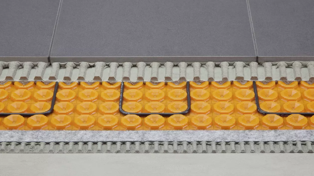 Querschnitt durch einen Fu&szlig;bodenaufbau mit einer elektrischen Heizung auf Entkopplungsmatte und abschlie&szlig;endem Fliesenbelag