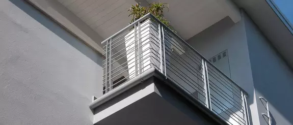 Gebouw met balkon waarin het gootsysteem Schl&uuml;ter-BARIN voor het afvoeren van water is ge&iuml;nstalleerd.