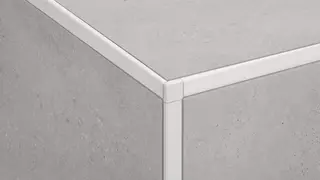 Kout s b&eacute;žov&yacute;mi dlaždicemi s b&iacute;l&yacute;m zakončovac&iacute;m profilem