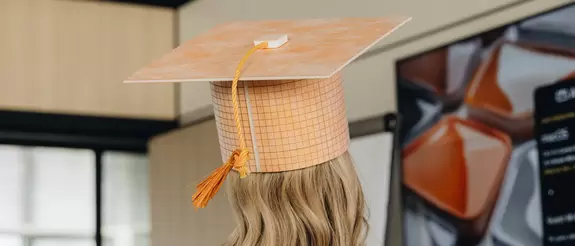 Hinterkopf einer Werkstudentin, die einen Absolventenhut aus KERDI-BOARD, einem Schl&uuml;ter-Produkt, auf dem Kopf tr&auml;gt