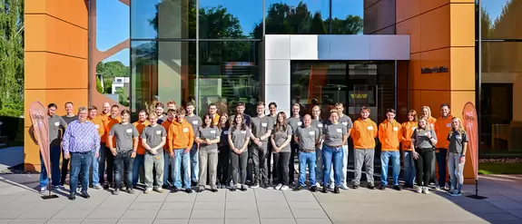 Gruppenfoto mit Gesch&auml;ftsf&uuml;hrer Udo Schl&uuml;ter, Ausbildern und zahlreichen Schl&uuml;ter-Azubis vor dem Schulungszentrum, der Schl&uuml;ter-WorkBox