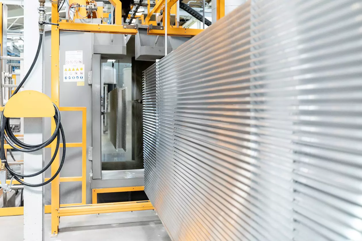 Les profil&eacute;s sont introduits dans la machine d'application des finitions structur&eacute;es.