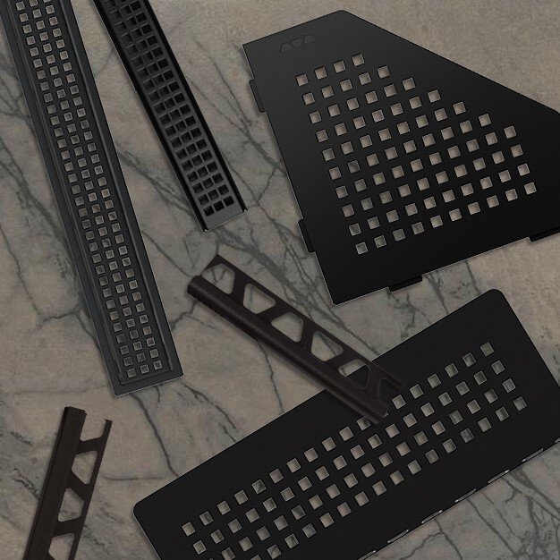 Grilles de caniveau, profils et étagères en formes triangulaires et rectangulaires, exposés sur un carrelage en marbre.