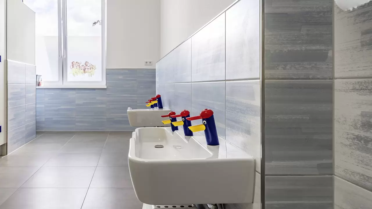 Kindgerechte Waschtische mit bunten Wasserh&auml;hnen in Entenform im Kindergarten der Marktschule