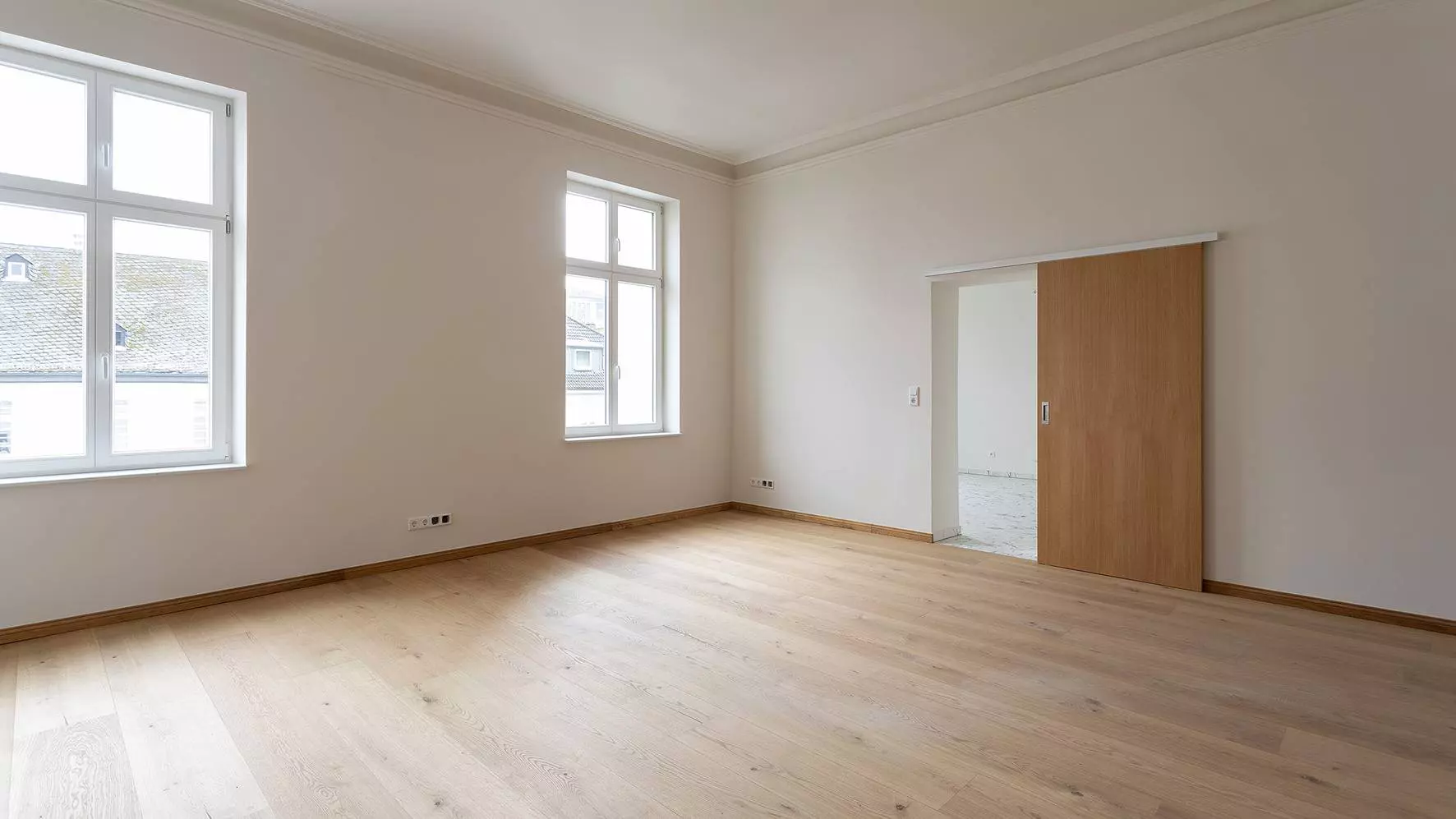 Fertig renovierter Wohnraum in der Villa Cosack mit gro&szlig;en Fenstern und Holzboden