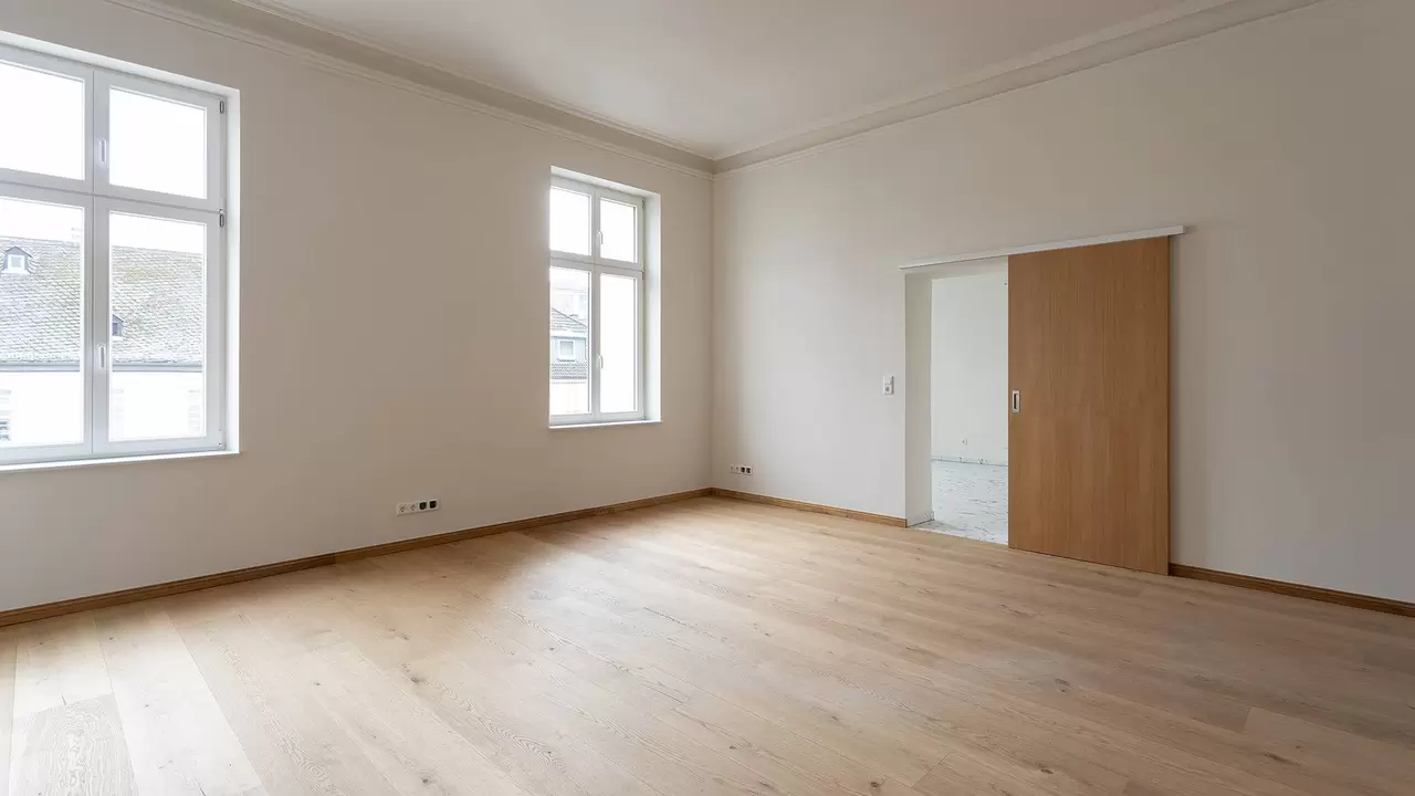 Fertig renovierter Wohnraum in der Villa Cosack mit gro&szlig;en Fenstern und Holzboden