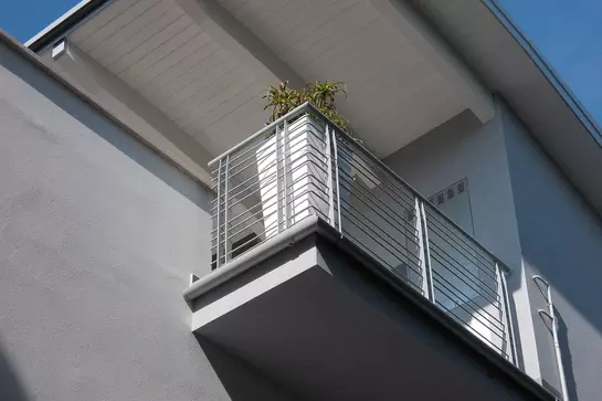 Gebouw met balkon waarin het gootsysteem Schl&uuml;ter-BARIN voor het afvoeren van water is ge&iuml;nstalleerd.
