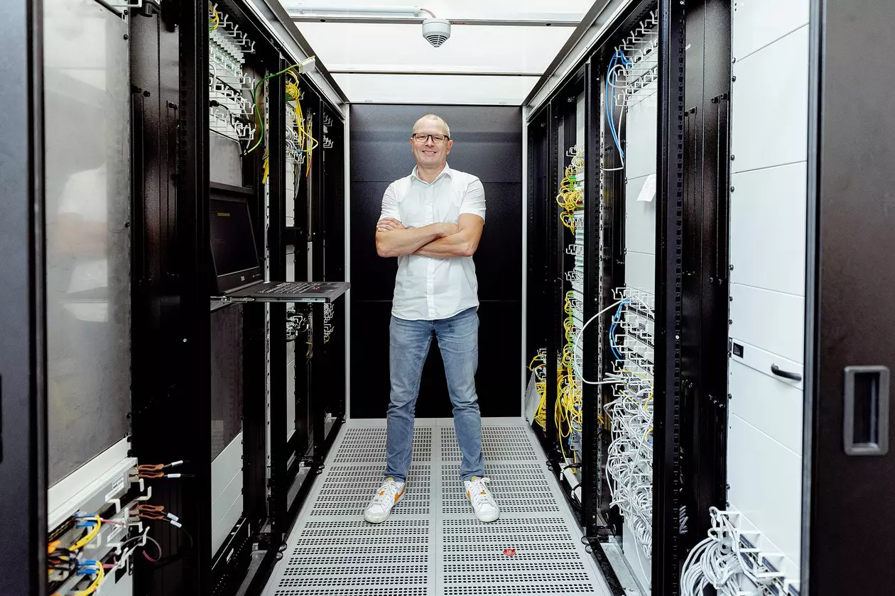 Un collaborateur masculin du service informatique se trouve entre les serveurs du centre de donn&eacute;es de Schl&uuml;ter-Systems.