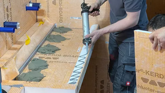 Řemesln&iacute;k lep&iacute; umyvadlo na m&iacute;ru z desek Schl&uuml;ter-KERDI-BOARD.
