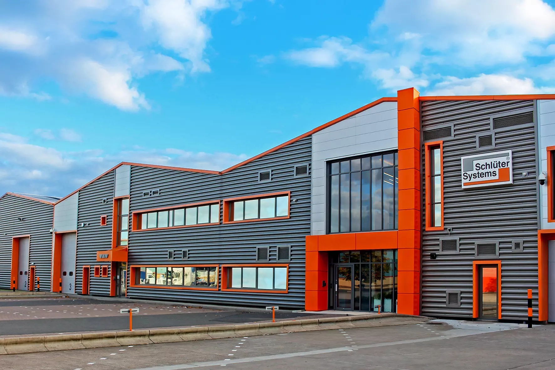 View from the front of the Schl&uuml;ter-Systems company building in Coalville, Leicestershire, UK, under a slightly clouded blue sky