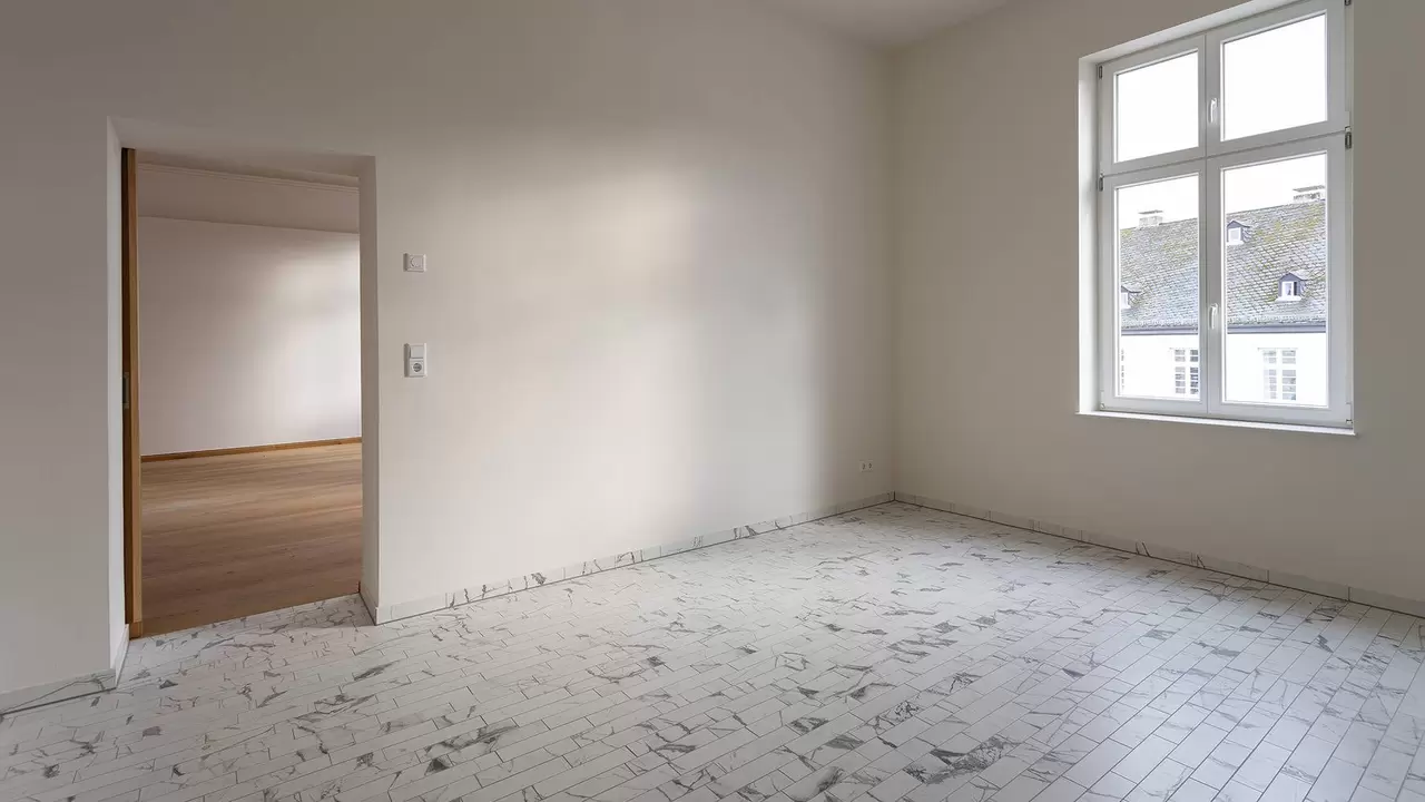Mit kleinformatigen, marmorierten Fliesen ausgestatteter Wohnraum in der renovierten Villa Cosack