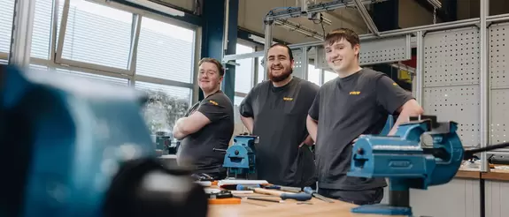 Drei technische Azubis stehen in der Instandhaltung an der Azubi-WerkBox
