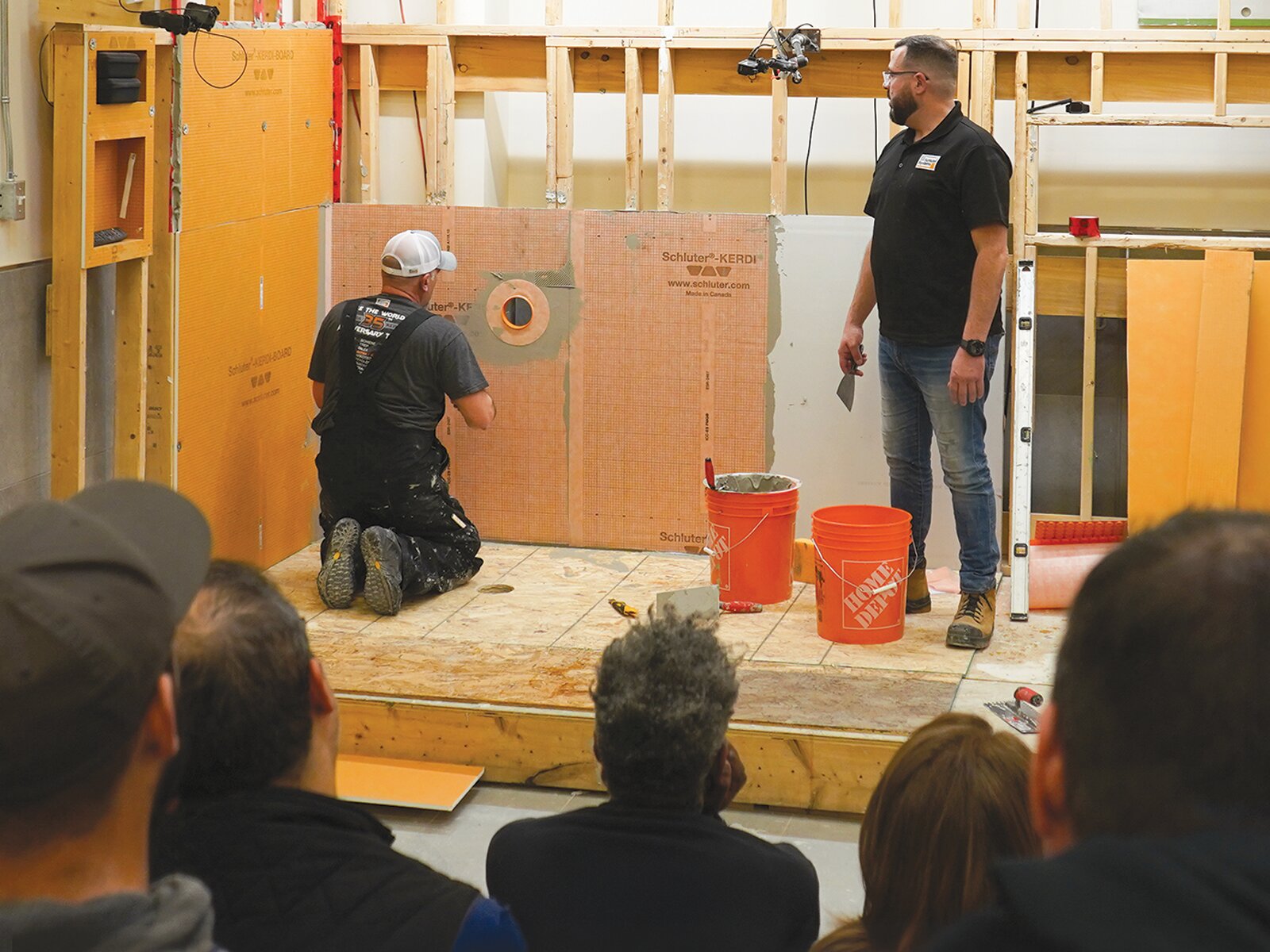Instructor demonstrating how to install Schluter Systems KERDI waterproofing at a hands-on training session