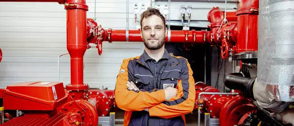 Un collaborateur masculin du service Facility Management devant l’installation de filtration chez Schl&uuml;ter-Systems.