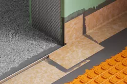 Produktdetailaufnahme eines mit KERDI-CID abgedichteten T&uuml;rdurchgangs mit Schiene, Formteilen, Kleber und DITRA-Entkopplungsmatte