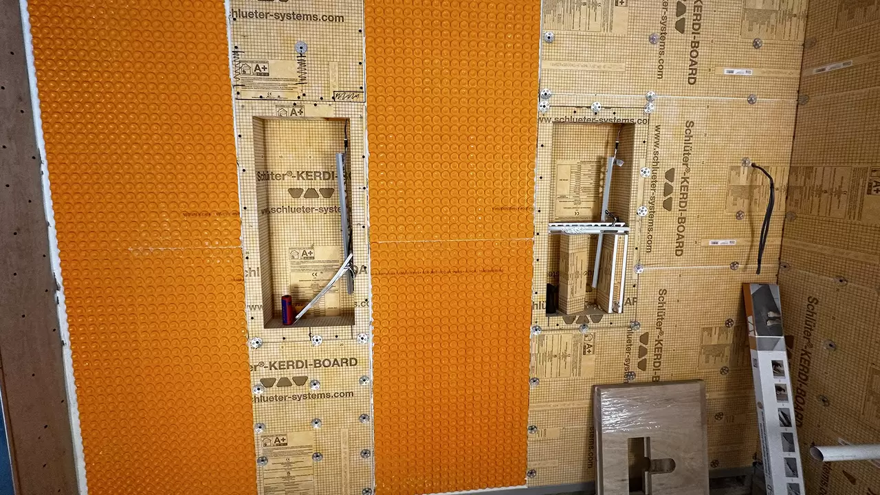 Bathroom construction site with building substrate, orange uncoupling mat and wall niches