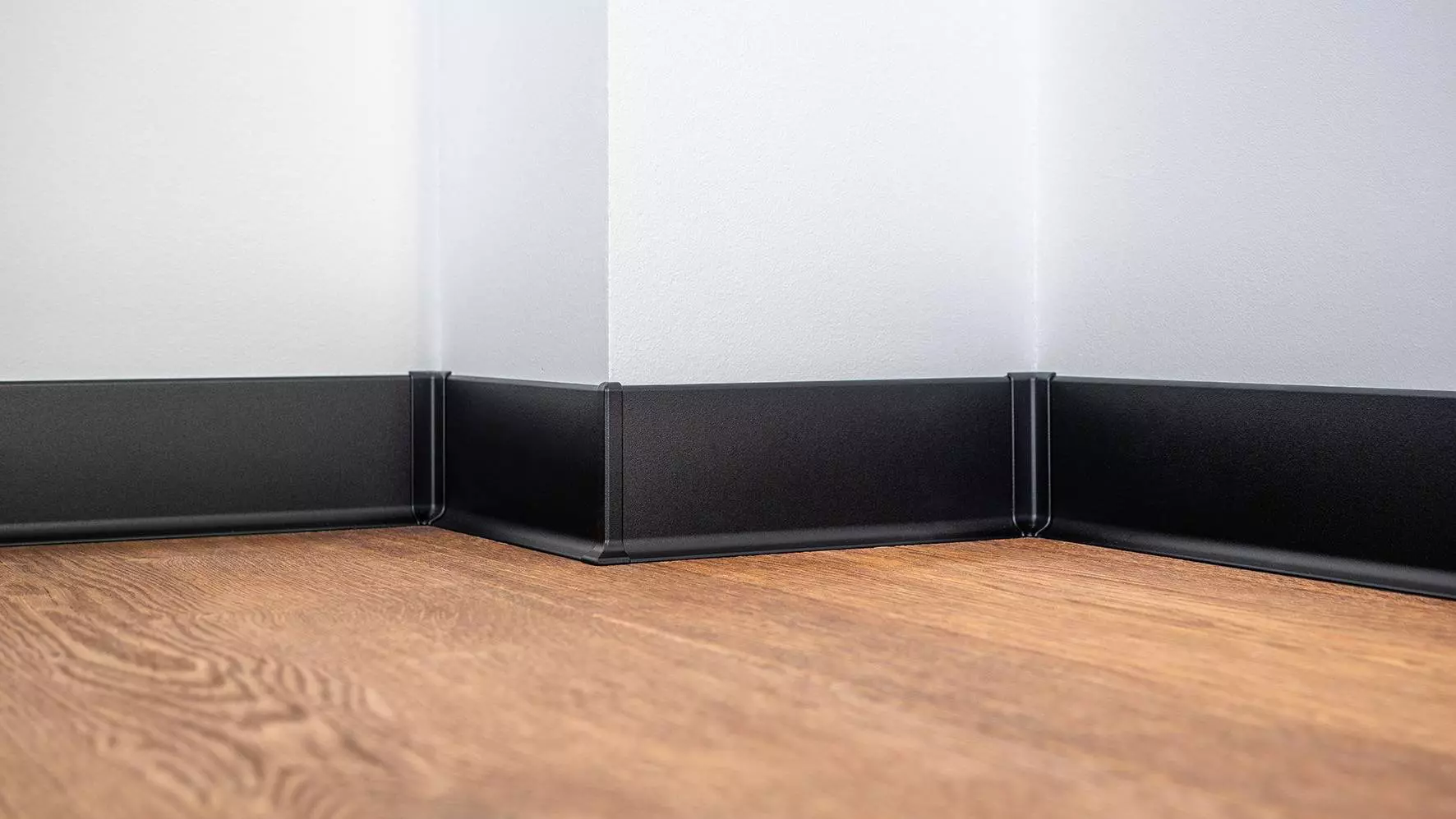 Schwarze Sockelleiste an heller Wand