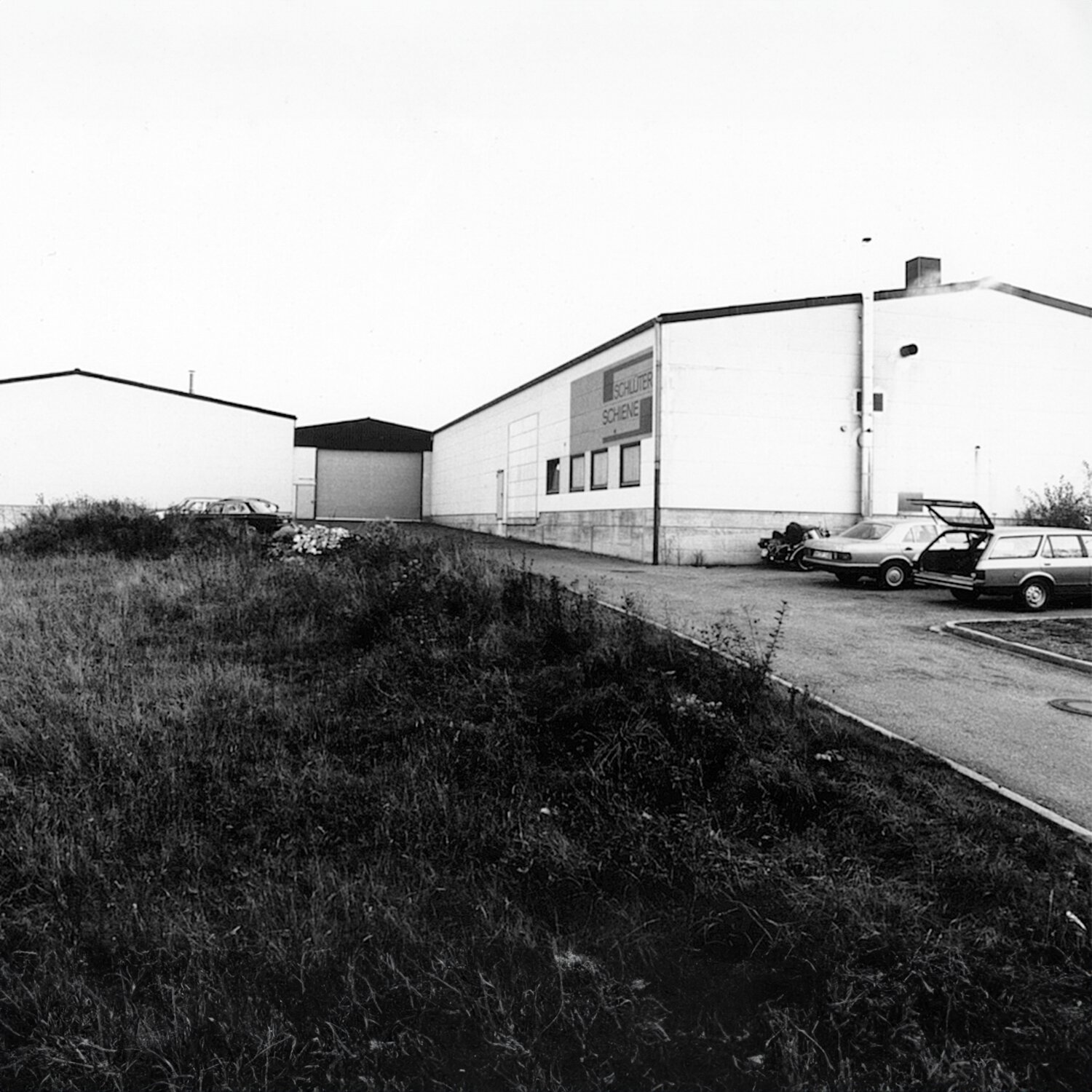 Image en noir et blanc du premier bâtiment de bureaux de Schluter Systems.