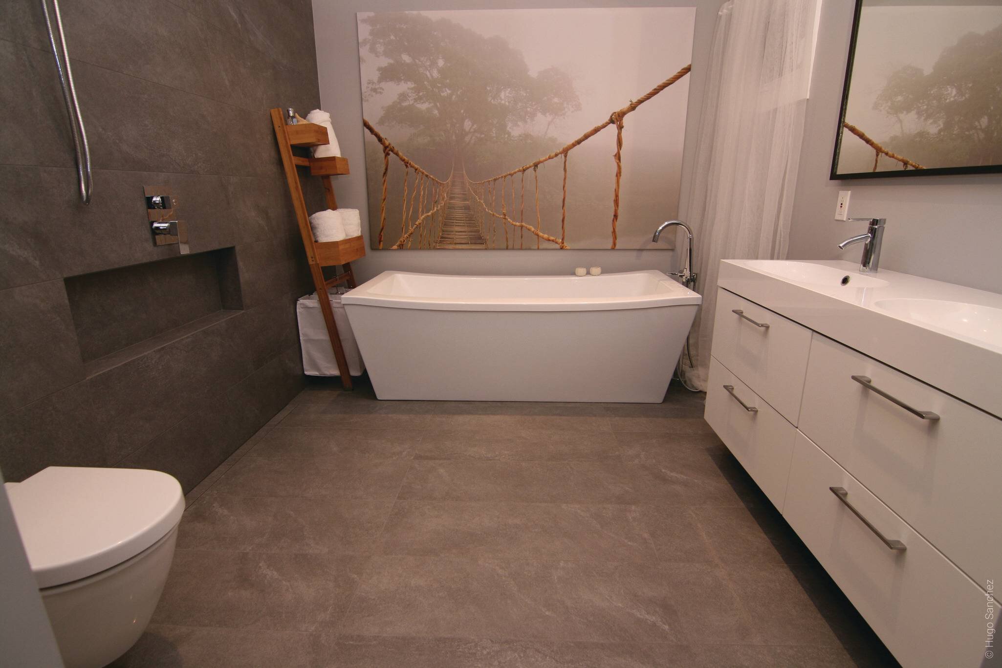 Salle de bain moderne avec douche ouverte sans seuil incluant une vanité blanche et un bain