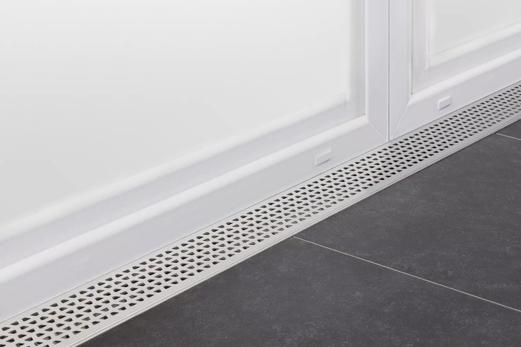 Schl&uuml;ter-TROBA-LINE voor het afvoeren van oppervlaktewater tussen terrastegels en balkondeur.