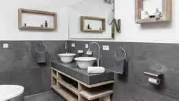 Moderner Doppelwaschtisch mit dunkelgrauem Unterbau und dunkelgrauem Fliesenspiegel und gleichfarbigen QUADEC-Profilen als Kantenschutz