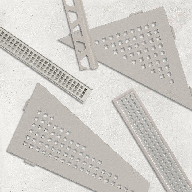 Une présentation d'étagères de douche, profils et grille de caniveau couleur grège dans un design assorti et cohérent de perforations carrées.